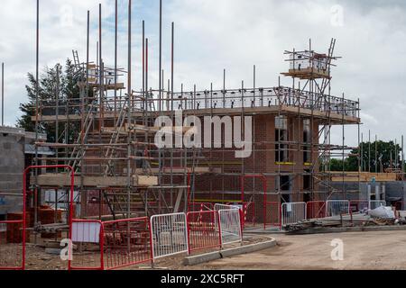 Slough, Großbritannien. Juni 2024. Bellway Homes haben mit dem Bau einer neuen Entwicklung von Wohnungen und 3-Zimmer-Häusern auf dem Gelände des ehemaligen Magnet Lesiure Centre in Slough, Berkshire begonnen. Der Standort wurde während der COVID-19-Pandemie als riesiger COVID-19-Teststandort genutzt. Der heute Montem Square heißt, überblickt den berühmten Montem Mound (im Bild), der ein geplantes antikes Monument ist. Die Häuser haben auch einen Blick auf Windsor Castle. In Slough wird viel gebaut, da es an der Elizabeth Line nach London liegt. Kredit: Maureen McLean/Alamy Stockfoto