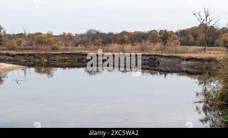 Siwerskyi Donets Flussufer in der Ukraine mit herbstlicher Natur und grauen Himmelsreflexen Stockfoto