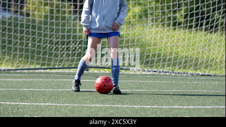 Kinderfüße führen den Ball während des Fußballtrainings aus nächster Nähe Stockfoto