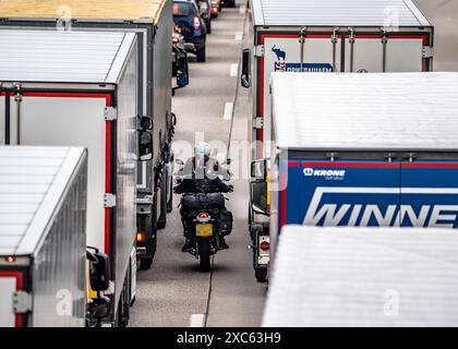 Motorradfahrer drängen sich in der Fahrbahnmitte zwischen den Fahrzeugen vorbei, bei einem 9 km langer Stau auf der Autobahn A40 in Richtung Osten, zwischen der Niederländischen Grenze bei Venlo, vor der Anschlussstelle Wankum, wegen einer Baustelle, Verkehrsführung auf eine Spur, viele LKW im Stau, NRW, Deutschland, Autobahnstau *** Motorradfahrer quetschen mitten auf der Straße zwischen den Fahrzeugen vorbei, in einem 9 km langen Stau auf der Autobahn A40 in östlicher Richtung, zwischen der niederländischen Grenze bei Venlo, vor der Kreuzung Wankum, wegen einer Baustelle, Verkehrsführung auf eine Spur, viele LKW Stockfoto