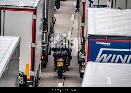 Motorradfahrer drängen sich in der Fahrbahnmitte zwischen den Fahrzeugen vorbei, bei einem 9 km langer Stau auf der Autobahn A40 in Richtung Osten, zwischen der Niederländischen Grenze bei Venlo, vor der Anschlussstelle Wankum, wegen einer Baustelle, Verkehrsführung auf eine Spur, viele LKW im Stau, NRW, Deutschland, Autobahnstau *** Motorradfahrer quetschen mitten auf der Straße zwischen den Fahrzeugen vorbei, in einem 9 km langen Stau auf der Autobahn A40 in östlicher Richtung, zwischen der niederländischen Grenze bei Venlo, vor der Kreuzung Wankum, wegen einer Baustelle, Verkehrsführung auf eine Spur, viele LKW Stockfoto