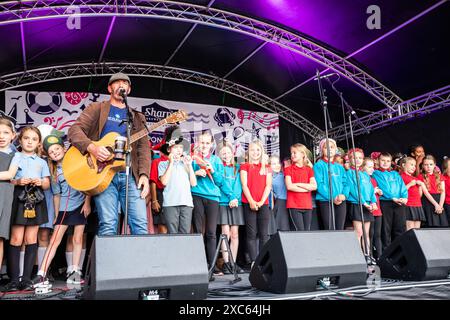 Falmouth, Cornwall, 14. Juni 2024, das Falmouth International Sea Shanty Festival ist das ganze Wochenende über im Gange. Riesige Menschenmassen waren anwesend, um all die SEA Shanty's zu beobachten und zu hören Will Keating besuchte und spielte auf der Bühne zusammen mit den Kindern der Falmouth Primary School und lehrte ihnen, wie man auf Cornish bis zehn zählt. Quelle: Keith Larby/Alamy Live News Stockfoto