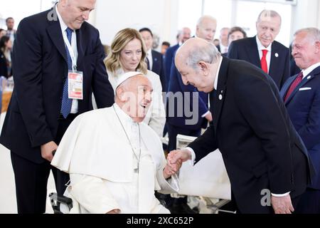 Apulien, Italien. Juni 2024. Papst Franziskus, links, begrüßt den algerischen Präsidenten Abdelmadjid Tebboune, rechts, wie die italienische Premierministerin Giorgia Meloni, Mitte, vor einer Sondersitzung des G7-Gipfels im Borgo Egnazia Resort am 14. Juni 2024 in Apulien, Italien, zusieht. Papst Franziskus war der erste Papst, der vor dem jährlichen Treffen der Gruppe der sieben Nationen sprach. Quelle: Presidenza del Consiglio/G7 Italia 2024/Alamy Live News Stockfoto