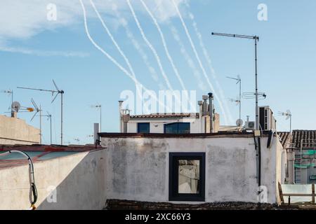 Rauchspur von mehreren Militärraketen auf dem Hintergrund des Himmels und der Häuser. Konzept: Raketenangriff, Luftwarnung, Krieg im Nahen Osten, Rakete A Stockfoto