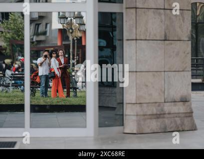 Reflexion zweier Freunde, die im urbanen Stadtbild posieren und fotografieren Stockfoto