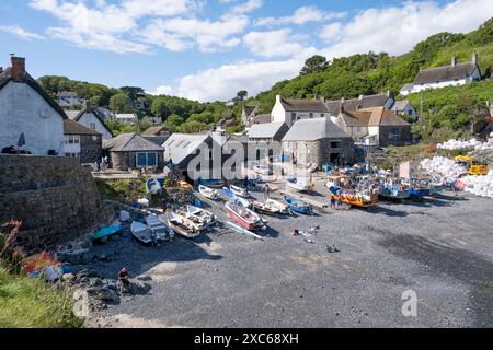 Der Fischerhafen im Dorf Cadgwith, Cornwall, England, mit Handwerkskunst am Kieselstrand. Stockfoto