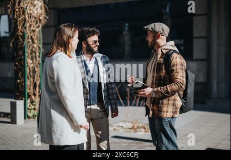 Junge Unternehmer bei einem Treffen im Freien, bei dem Strategien und Markttrends diskutiert werden Stockfoto