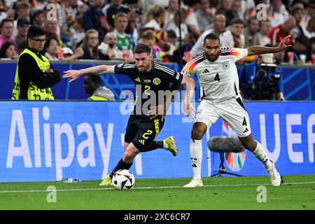 München, Deutschland. Juni 2024. Fußball, UEFA Euro 2024, Europameisterschaft, Deutschland - Schottland, Vorrunde, Gruppe A, Spieltag 1, Football Arena München, Schottland Anthony Ralston (l) und Deutschland Jonathan Tah kämpfen um den Ball. Quelle: Federico Gambarini/dpa/Alamy Live News Stockfoto