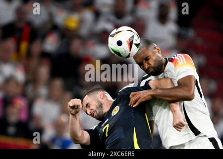 München, Deutschland. Juni 2024. Fußball, UEFA Euro 2024, Europameisterschaft, Deutschland - Schottland, Vorrunde, Gruppe A, Spieltag 1, Fußball Arena München, Deutschland Jonathan Tah (r) und Schottland John McGinn in einem Kopfballduell. Quelle: Federico Gambarini/dpa/Alamy Live News Stockfoto
