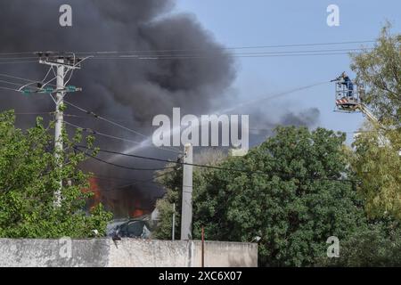 Athen, Griechenland. Juni 2024. Flammen und schwarzer Rauch steigen in den Himmel, während ein Feuerwehrmann mit einem Wasserkanon gegen ein Feuer kämpft, das durch mehrere Explosionen in einer Kochgeschirrfabrik im nördlichen Athener Vorort Kifissia verursacht wird. Die Behörden warnten die Bewohner, wegen einer möglichen toxischen Wolke drinnen zu bleiben. (Kreditbild: © Dimitris Aspiotis/Pacific Press via ZUMA Press Wire) NUR REDAKTIONELLE VERWENDUNG! Nicht für kommerzielle ZWECKE! Stockfoto