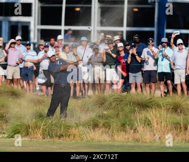 Pinehurst, North Carolina, USA. Juni 2024. Tiger Woods aus Jupiter, Florida, spielt seinen zweiten Schuss aus der natürlichen Umgebung entlang des 18. Fairways während der zweiten Runde der 124. U.S. Open am 14. Juni 2024 im Pinehurst Resort & Country Club (Kurs Nr. 2) in Pinehurst, North Carolina. (Kreditbild: © Timothy L. Hale/ZUMA Press Wire) NUR REDAKTIONELLE VERWENDUNG! Nicht für kommerzielle ZWECKE! Stockfoto