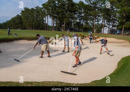 Pinehurst, North Carolina, USA. Juni 2024. Die Crews des USGA Grounds steigen in das erste Loch, um den Platz für die tomorrowÃs Eröffnungsrunde der 124. U.S. Open am 12. Juni 2024 im Pinehurst Resort & Country Club (Kurs Nr. 2) in Pinehurst, North Carolina, vorzubereiten. (Kreditbild: © Timothy L. Hale/ZUMA Press Wire) NUR REDAKTIONELLE VERWENDUNG! Nicht für kommerzielle ZWECKE! Stockfoto