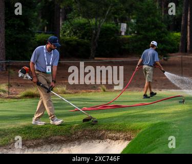 Pinehurst, North Carolina, USA. Juni 2024. Die Crews des USGA Grounds steigen in das erste Loch, um den Platz für die tomorrowÃs Eröffnungsrunde der 124. U.S. Open am 12. Juni 2024 im Pinehurst Resort & Country Club (Kurs Nr. 2) in Pinehurst, North Carolina, vorzubereiten. (Kreditbild: © Timothy L. Hale/ZUMA Press Wire) NUR REDAKTIONELLE VERWENDUNG! Nicht für kommerzielle ZWECKE! Stockfoto