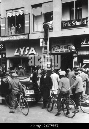 Ein Mann, der während des Boykotts jüdischer Unternehmen am 1. April 1933 ein antisemitisches Plakat aufklebt. Der Boykott jüdischer Unternehmen war die erste direkte antijüdische Aktion, die zum Ausschluss der Juden aus der Gesellschaft und schließlich zur Vernichtung führte und nur zwei Monate nach Hitlers Machtergreifung stattfand. Stockfoto