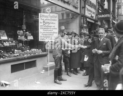 Mitglieder der Sturmabteilung (SA, die berüchtigten Brownshirts) während des Boykotts jüdischer Unternehmen vom 1. April 1933. Hier gibt es antisemitische Flugblätter in Berlin. Der Boykott jüdischer Unternehmen war die erste direkte antijüdische Aktion, die zum Ausschluss der Juden aus der Gesellschaft und schließlich zur Vernichtung führte und nur zwei Monate nach Hitlers Machtergreifung stattfand. Auf dem Schild steht: "Achtung, Deutsche! Diese jüdischen Besitzer der 5 P.S.-Geschäfte sind Parasiten und Bestattungskünstler deutscher Handwerkskunst! Sie zahlen Hungerlöhne an deutsche Arbeiter! Der Haupteigentümer ist der Stockfoto