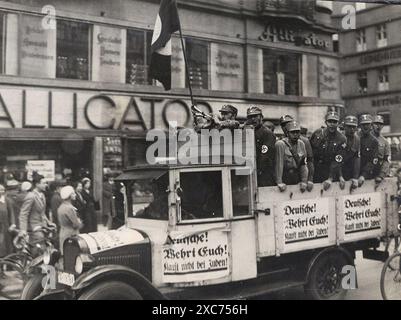 Ein LKW mit Mitgliedern der Sturmabteilung (SA, die berüchtigten Brownshirts) vor dem Alligator-Laden in Berlin. Das Auto ist mit Schildern/Plakaten mit dem anti-jüdischen Slogan „Deutsche! Wehrt Euch! Kauft nicht bei Juden! ('Deutsche! Verteidigen Sie sich! Kaufen Sie nicht von Juden!"). Dies war Teil einer landesweiten antisemitischen Boykott- und Propagandakampagne, die jüdische Unternehmen am 1. April 1933 schikanierte. Stockfoto