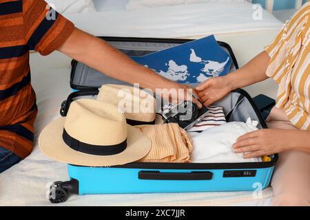 Seniorenpaar, das Koffer zu Hause aufs Bett packt, Nahaufnahme Stockfoto