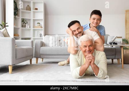 Teenager mit Vater und Großvater, die zu Hause auf dem Boden liegen Stockfoto