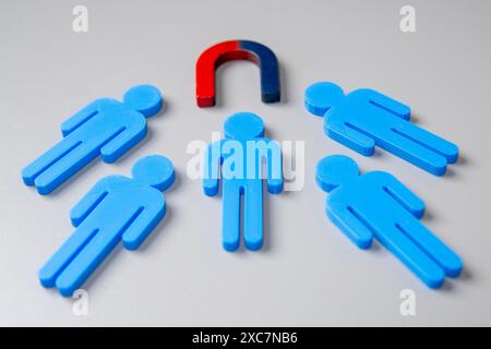 Magnet zieht menschliche Figur an. Kundenakquise und Kundenbindungskonzept Stockfoto