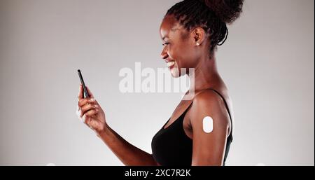 Medizintechniker überwachen den Blutzuckerspiegel des Patienten mithilfe der Smartphone-App zur Fernüberwachung und -Analyse von afroamerikanischen Frauen. Stockfoto