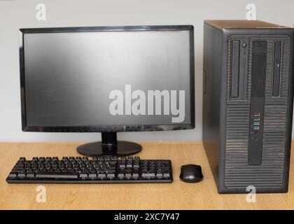 Computermonitor, mit Tastatur und Maus auf einem Holztisch. Stockfoto