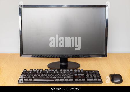 Vorderansicht eines modernen Desktop-Computers mit Monitor, Tastatur und Maus auf einem Schreibtisch. Stockfoto