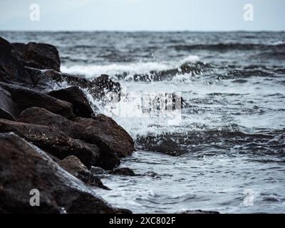 Wellen aus der Sagami-Bucht brechen entlang der Betonbrocken der Erosionskontrolle neben Katase Harbor, Fujisawa, Japan. Stockfoto