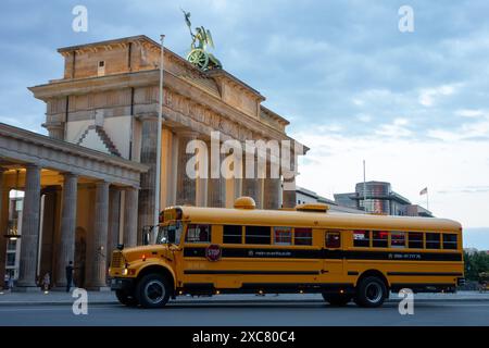 BERLIN, DEUTSCHLAND - 6. AUGUST 2016: Amerikanischer gelber Schulbus International 3800 von Mein-Eventbus.de Unternehmen vor dem Brandenburger Tor in der Abenddämmerung Stockfoto