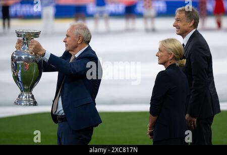 München, Deutschland. Juni 2024. Fußball: UEFA Euro 2024, Europameisterschaft, Deutschland - Schottland, Vorrunde, Gruppe A, Heidi Beckenbauer (M), Witwe des ehemaligen Nationalspielers und Trainers Franz Beckenbauer, bringt die Trophäe mit Bernard Dietz (l) und Jürgen Klinsmann, den deutschen Kapitänen bei den Europameistertiteln 1980 und 1996, in die Arena. Quelle: Sven Hoppe/dpa/Alamy Live News Stockfoto