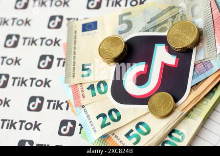 KIEW, UKRAINE - 20. APRIL 2024 TikTok-Logo und viele Euro-Geldscheine. Symbol der berühmten Plattform des sozialen Netzwerks und der europäischen Geldscheine aus nächster Nähe Stockfoto