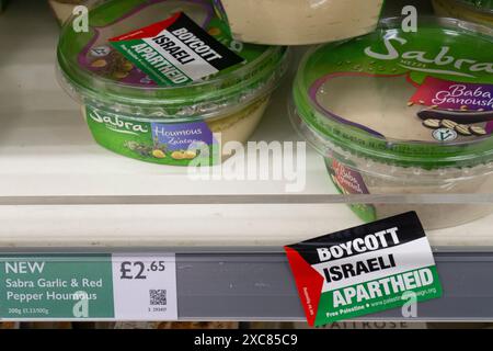 London, Großbritannien. Juni 2024. In einem Zweig von Waitrose in Balham wurden Aufkleber auf die Wannen von Sabra-Humous und das darunter liegende Regal angebracht, um einen Konsumboykott israelischer Produkte zu fördern, während das palästinensische Volk noch immer Angriffen in Gaza ausgesetzt ist und von Israel die Eigenstaatlichkeit verweigert wird. Quelle: Anna Watson/Alamy Live News Stockfoto