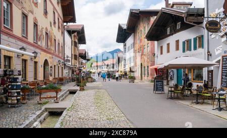 Die Marktgemeinde Mittenwald mit historischen Gebäuden Mittenwald liegt im Landkreis Garmisch-Partenkirchen, ist Deutschlands höchstgelegener Luftkurort und berühmt wegen der traditionellen Kunst des Geigenbaus. In der historischen Altstadt sind viele Häuser auf der Fassade mit kunstvoller Lüftlmalerei geschmückt. Blick in die Fußgängerzone mit den historischen Gebäuden der Altstadt. Mittenwald Bayern Deutschland *** die Marktstadt Mittenwald mit historischen Gebäuden liegt im Stadtteil Garmisch Partenkirchen, ist Deutschlands höchstes Luftkurort und berühmt für Stockfoto