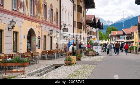 Die Marktgemeinde Mittenwald mit historischen Gebäuden Mittenwald liegt im Landkreis Garmisch-Partenkirchen, ist Deutschlands höchstgelegener Luftkurort und berühmt wegen der traditionellen Kunst des Geigenbaus. In der historischen Altstadt sind viele Häuser auf der Fassade mit kunstvoller Lüftlmalerei geschmückt. Blick in die Fußgängerzone mit den historischen Gebäuden der Altstadt. Mittenwald Bayern Deutschland *** die Marktstadt Mittenwald mit historischen Gebäuden liegt im Stadtteil Garmisch Partenkirchen, ist Deutschlands höchstes Luftkurort und berühmt für Stockfoto