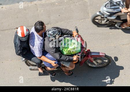 SAIGON, VIETNAM, 17. Dezember 2017, Ein Trio von Männern fährt zusammen auf einem Motorrad in den Straßen von Saigon Stockfoto