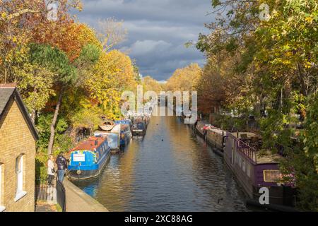 Die Kanäle von Little Venice an einem Herbsttag. Hausboote säumen den Kanal und Herbstblätter machen die Bäume bunt. Stockfoto