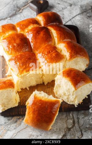 Hawaiianische Brötchen, portugiesisches süßes Brot, weiche und dehnbare Brötchen aus der Nähe auf dem Holzbrett auf dem Tisch. Vertikal Stockfoto