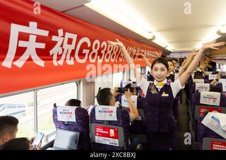 (240615) -- SHANGHAI, 15. Juni 2024 (Xinhua) -- Stewardessen treten für Passagiere im Zug G8388 auf, 15. Juni 2024. Im Yangtse-Delta, einer wirtschaftlich lebendigen Region in China, wurde am Samstag die erste Eisenbahnschleife in Betrieb genommen, die die Metropole Shanghai mit den wichtigsten Städten des regionalen Clusters durchführte. Der erste Zugbetrieb auf der Schleifenbahn wurde am Samstag um 10:27 Uhr vom Bahnhof Shanghai aus gestartet. Für eine vollständige Rundfahrt soll der Zug acht Stunden und neun Minuten auf einer Strecke fahren, die sich über 1.200 km erstreckt (Xinhua/Wang Xi) Stockfoto