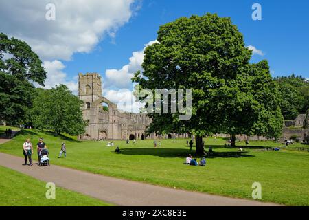 Fountains Abbey mit Menschen, die die Landschaft und das Gelände der Abtei genießen. Ripon, North Yorkshire, England, Vereinigtes Königreich. Stockfoto