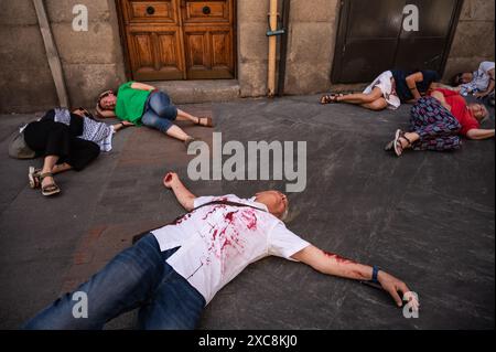 Madrid, Spanien. Juni 2024. Menschen, die auf der Straße liegen, als wären sie tot, bedeckt mit gefälschtem Blut während einer Darstellung der Folgen eines Bombenanschlags. Aktivisten protestieren gegen die Angriffe Israels im Gazastreifen und fordern einen dauerhaften Waffenstillstand in Palästina. Quelle: Marcos del Mazo/Alamy Live News Stockfoto