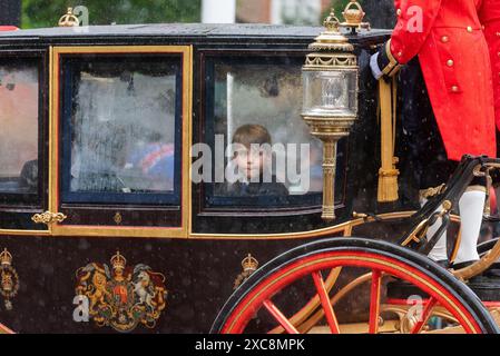 The Mall, Westminster, London, Großbritannien. Juni 2024. Die königliche Familie, massenhafte Bands und Truppen sind von der Horse Guards Parade zur Truppe der Farbe zurückgekehrt, auch bekannt als die Geburtstagsparade des Königs. Für das Jahr 2024 fällt die Ehre der Number 9 Company Irish Guards, ihre Farbe zu truppen, die manchmal starken Regen erlebt hatte. Prinz Louis von Wales in einem Kutscher im Regen Stockfoto