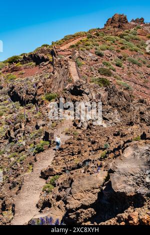 Weibliche Wanderer, die einen steilen Pfad zwischen vulkanischen Felsen, Kanarischen Inseln, La Palma besteigen. Stockfoto