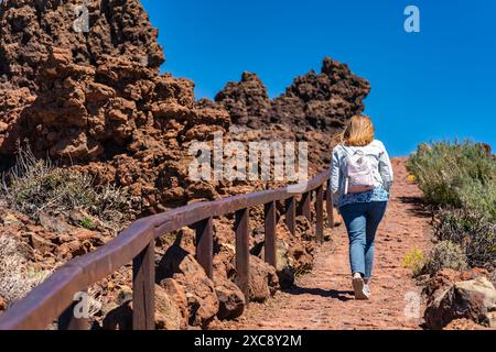 Weibliche Wanderer, die einen steilen Pfad zwischen vulkanischen Felsen, Kanarischen Inseln, La Palma besteigen. Stockfoto