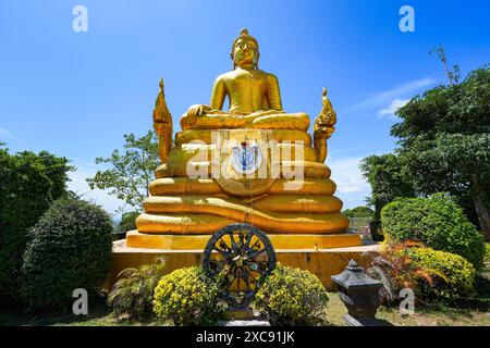 Goldene sitzende Buddha-Statue hinter dem Großen Buddha von Phuket alias Ming Mongkol Buddha, eine sitzende Maravijaya Buddha-Statue. Es sitzt auf einem Stockfoto