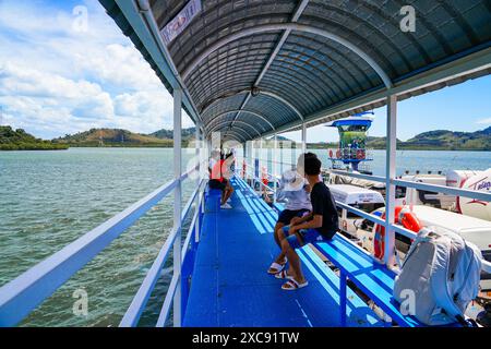 Thailändische Einheimische sitzen auf einem Fußweg auf der Fährverbindung zwischen Ko Lanta Noi und Ko Lanta Yai in der Andamanensee, Provinz Krabi, Thailand Stockfoto