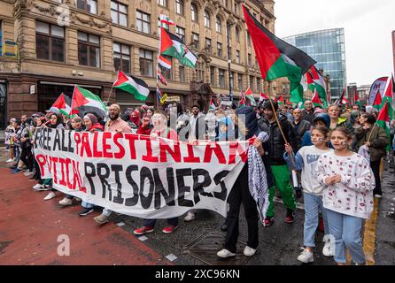 Manchester, Großbritannien. Juni 2024. Palästina Gaza-Krieg Proteste in Manchester Großbritannien bei starkem Regen. Demonstranten marschierten vom Petersplatz durch das Stadtzentrum. Auf Transparenten wurden Nachrichten geschrieben, in denen Israel aufgefordert wurde, politische Gefangene aus Palästina zu befreien und die Barclays Bank zu kritisieren. Quelle: GaryRobertsphotography/Alamy Live News Stockfoto