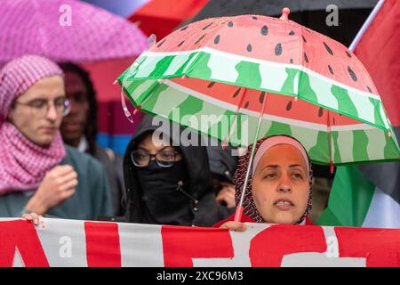 Manchester, Großbritannien. Juni 2024. Frau mit Wassermelonenschirm. Palästina Gaza-Krieg Proteste in Manchester Großbritannien bei starkem Regen. Demonstranten marschierten vom Petersplatz durch das Stadtzentrum. Auf Transparenten wurden Nachrichten geschrieben, in denen Israel aufgefordert wurde, politische Gefangene aus Palästina zu befreien und die Barclays Bank zu kritisieren. Quelle: GaryRobertsphotography/Alamy Live News Stockfoto