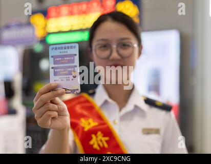 (240615) -- SHANGHAI, 15. Juni 2024 (Xinhua) -- Ein Mitarbeiter zeigt eine Erinnerungskarte an die Hochgeschwindigkeits-Schlafzüge D907 und D908 zwischen Shanghai und Hongkong am Bahnhof Shanghai Hongqiao im ostchinesischen Shanghai, 15. Juni 2024. Hochgeschwindigkeits-Schlafzüge, die Peking und Shanghai mit Hongkong verbinden, nahmen am Samstag ihren Betrieb auf. Die Reisezeit zwischen Peking und Hongkong wird auf 12 Stunden und 34 Minuten reduziert, die Reisezeit zwischen Shanghai und Hongkong auf 11 Stunden und 14 Minuten. Mit den neuen Diensten können Passagiere zwischen den Chinesen reisen Stockfoto