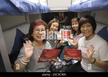(240615) -- HONGKONG, 15. Juni 2024 (Xinhua) -- Passagiere zeigen Geschenke, die sie an Bord des Hochgeschwindigkeits-Schlafzugs D910 erhalten haben, der am 15. Juni 2024 zum Pekinger Westbahnhof in Hongkong, Südchina, fährt. Hochgeschwindigkeits-Schlafzüge, die Peking und Shanghai mit Hongkong verbinden, nahmen am Samstag ihren Betrieb auf. Die Reisezeit zwischen Peking und Hongkong wird auf 12 Stunden und 34 Minuten reduziert, die Reisezeit zwischen Shanghai und Hongkong auf 11 Stunden und 14 Minuten. Mit den neuen Diensten können Passagiere über Nacht zwischen dem chinesischen Festland und Hongkong reisen Stockfoto