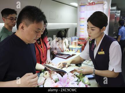 (240615) -- HONGKONG, 15. Juni 2024 (Xinhua) -- Passagiere bestellen Essen an Bord des Hochgeschwindigkeits-Schlafzugs D910, der am 15. Juni 2024 zum Pekinger Westbahnhof in Hongkong, Südchina, fährt. Hochgeschwindigkeits-Schlafzüge, die Peking und Shanghai mit Hongkong verbinden, nahmen am Samstag ihren Betrieb auf. Die Reisezeit zwischen Peking und Hongkong wird auf 12 Stunden und 34 Minuten reduziert, die Reisezeit zwischen Shanghai und Hongkong auf 11 Stunden und 14 Minuten. Mit den neuen Diensten können Passagiere über Nacht zwischen dem chinesischen Festland und Hongkong reisen. (Xinhua/Wang Sh Stockfoto