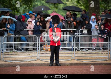 London, Großbritannien. Juni 2024. Schotten bewachen die Mall mit Mitgliedern der Öffentlichkeit hinter sich, die Regenschirme wegen der Wetterbedingungen halten. Die King's Birthday Parade, auch bekannt als Trooping the Colour, ist eine Militärprozession, die jedes Jahr zum offiziellen Geburtstag des britischen Monarchen stattfindet. Quelle: SOPA Images Limited/Alamy Live News Stockfoto